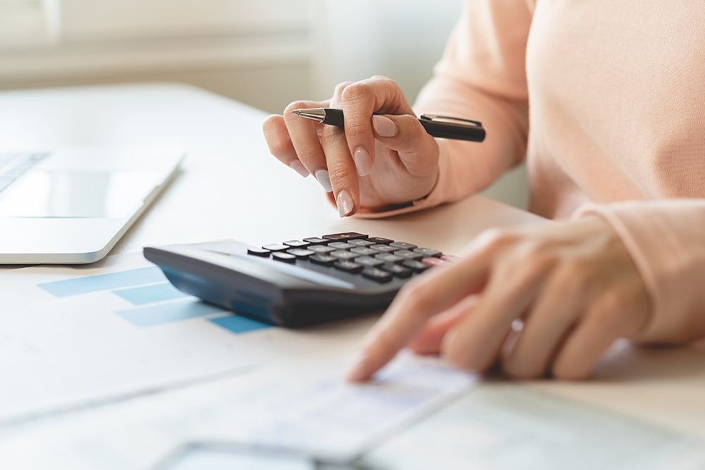 person using calculator and pen 